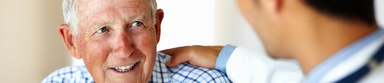 Doctor talking to patient while evaluating her arm