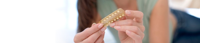 woman holding birth control pills