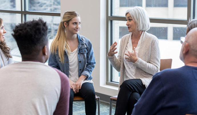 Woman talking in front of a group.
