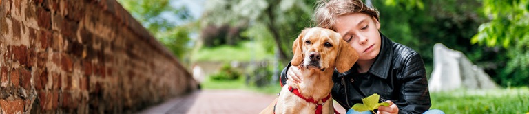 young boy sitting with dog