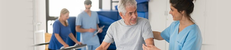 nurse helping old man walk