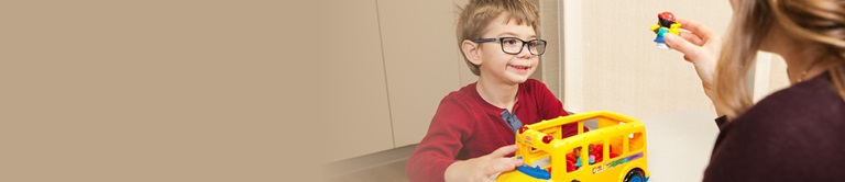 child playing with a toy schoolbus