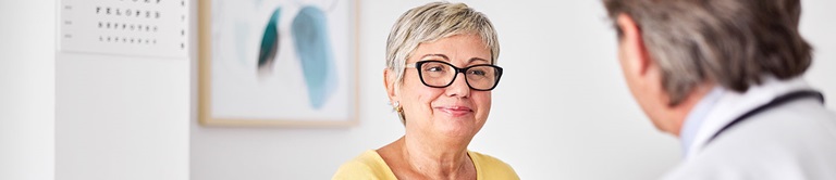 Woman smiling while talking to her doctor.
